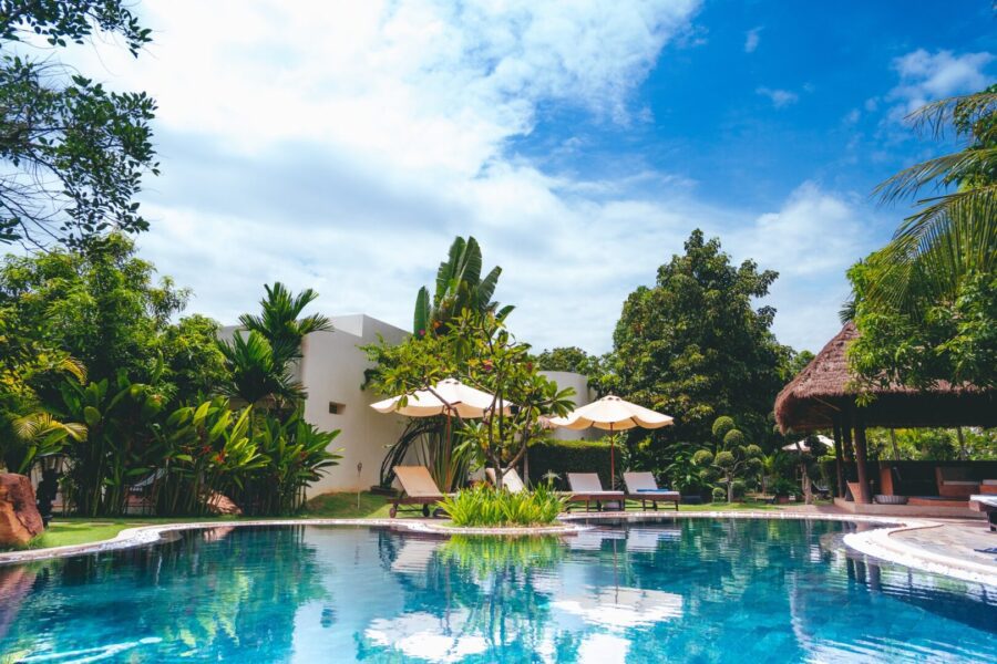 Pool and tiki area with tropical trees